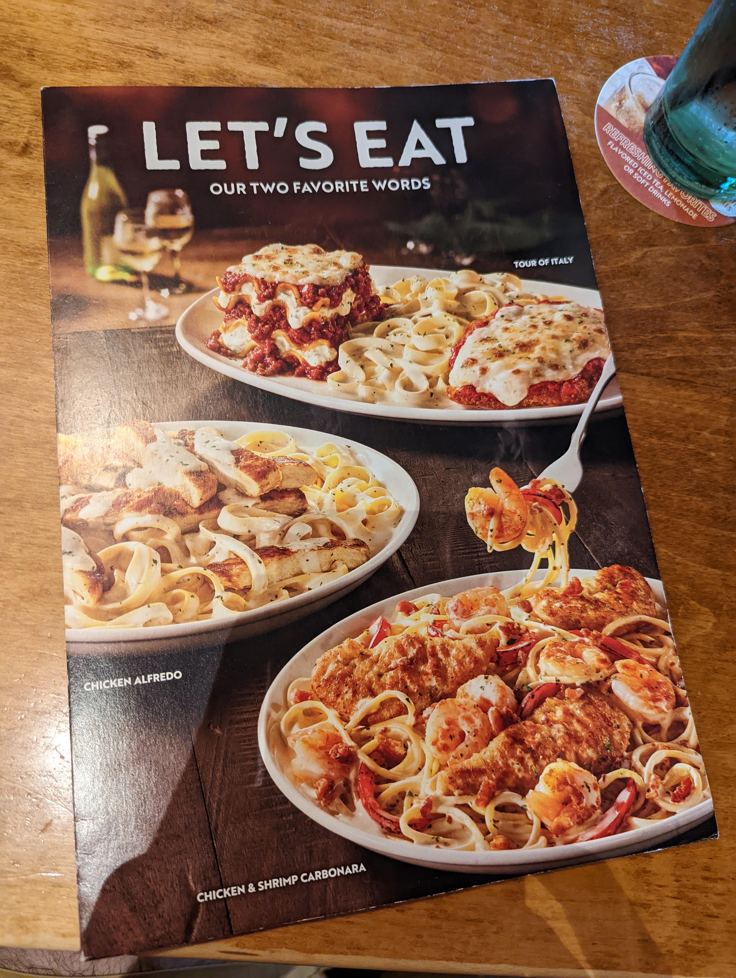 A photo of Olive Garden menu with a picture of their carbonara dish.